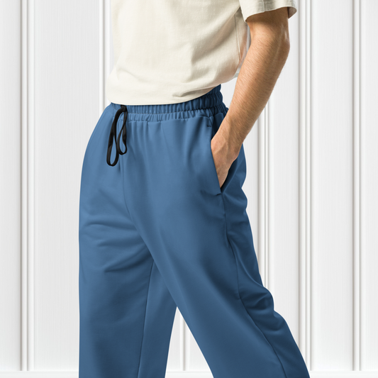 A pair of unisex wide leg joggers that are a ocean blue color from the top to the bottom with the strings of the sweats being black.
