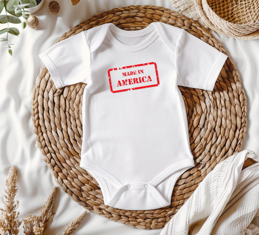 On the front of this custom baby onesie are the words Made In America in a rectangular box that makes it look like a stamp, on the back of this bodysuit is the American flag.