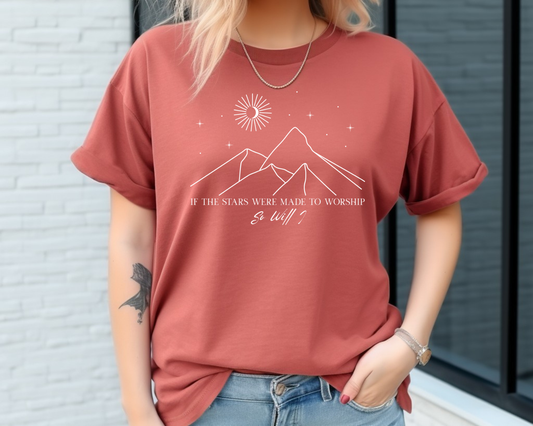 On the front of this custom Christian short sleeve shirt is a line drawing of mountains, and a moon and stars above the mountains, underneath the image are the words If the stars were made to worship so will I.