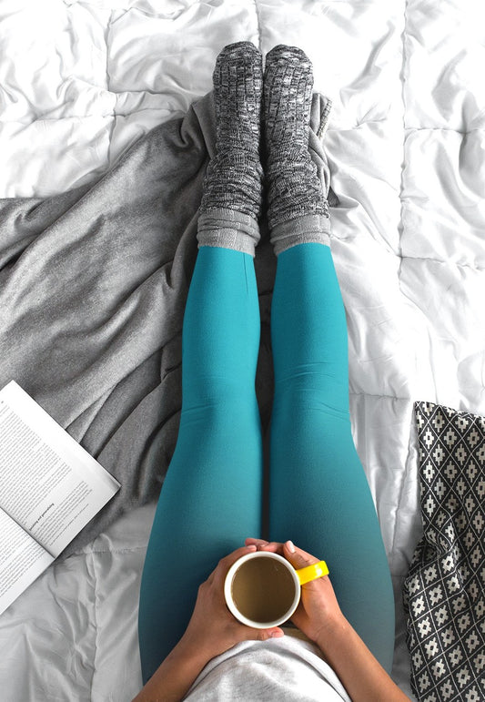 These custom handmade women's leggings have a ombre pattern with the top of the leggings being black in color then it shifting to a turquoise blue at the bottom of the pants.