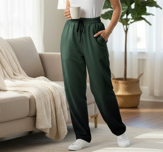 A custom pair of handmade unisex joggers that have an ombre pattern, the top of the pants have a teal green color that shifts to black at the bottom of the sweatpants, there is a black tie around the waist.