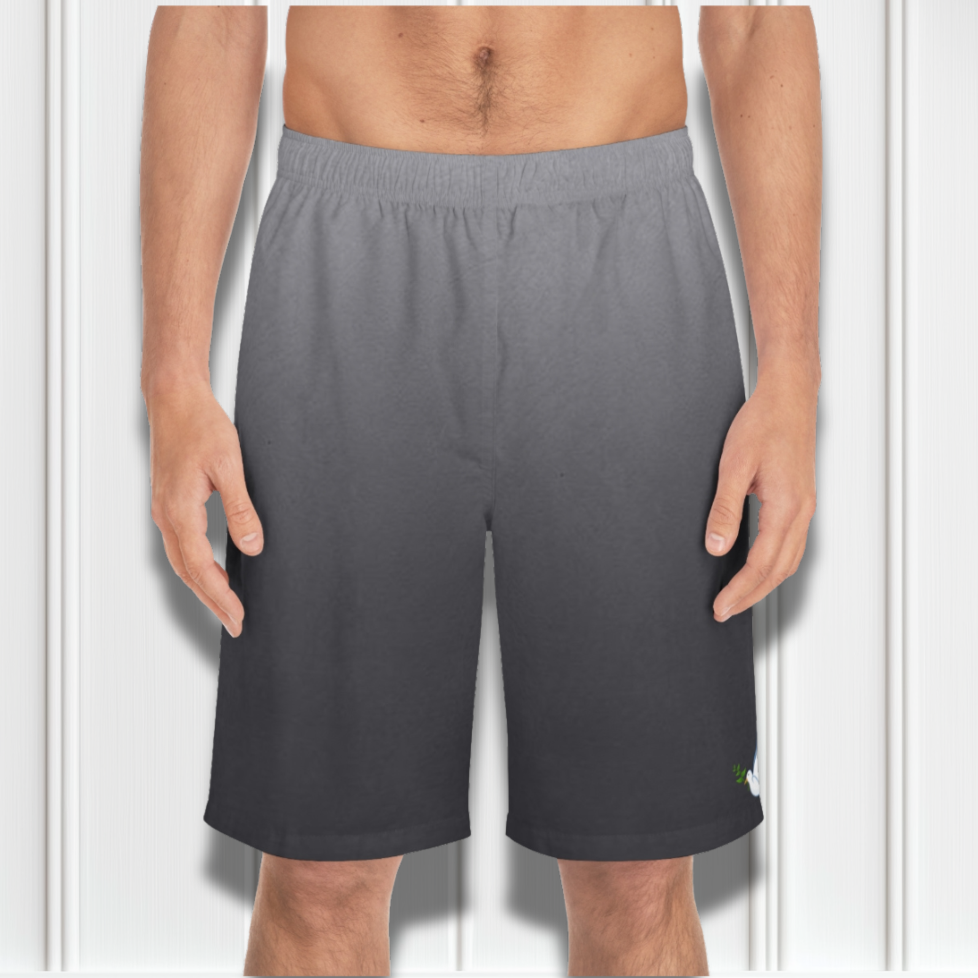 These custom men's board shorts feature a unique design with a ombre pattern starting with a light grey at the top then fading to a dark grey at the bottom, there is a symbol of a dove carrying a fig leaf on the front left side of the shorts just at the knee.