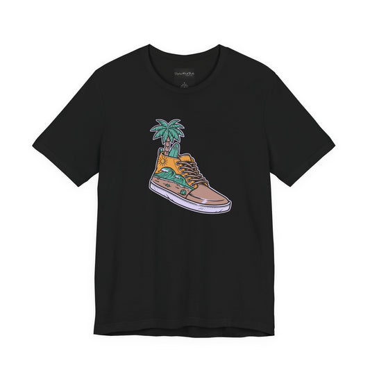 On the front of this custom handmade short sleeve shirt is an image of a high top running shoe with ocean waves running along the side of the shoe, coming out of the top of the shoe where your foot goes is a palm tree and a surf board.