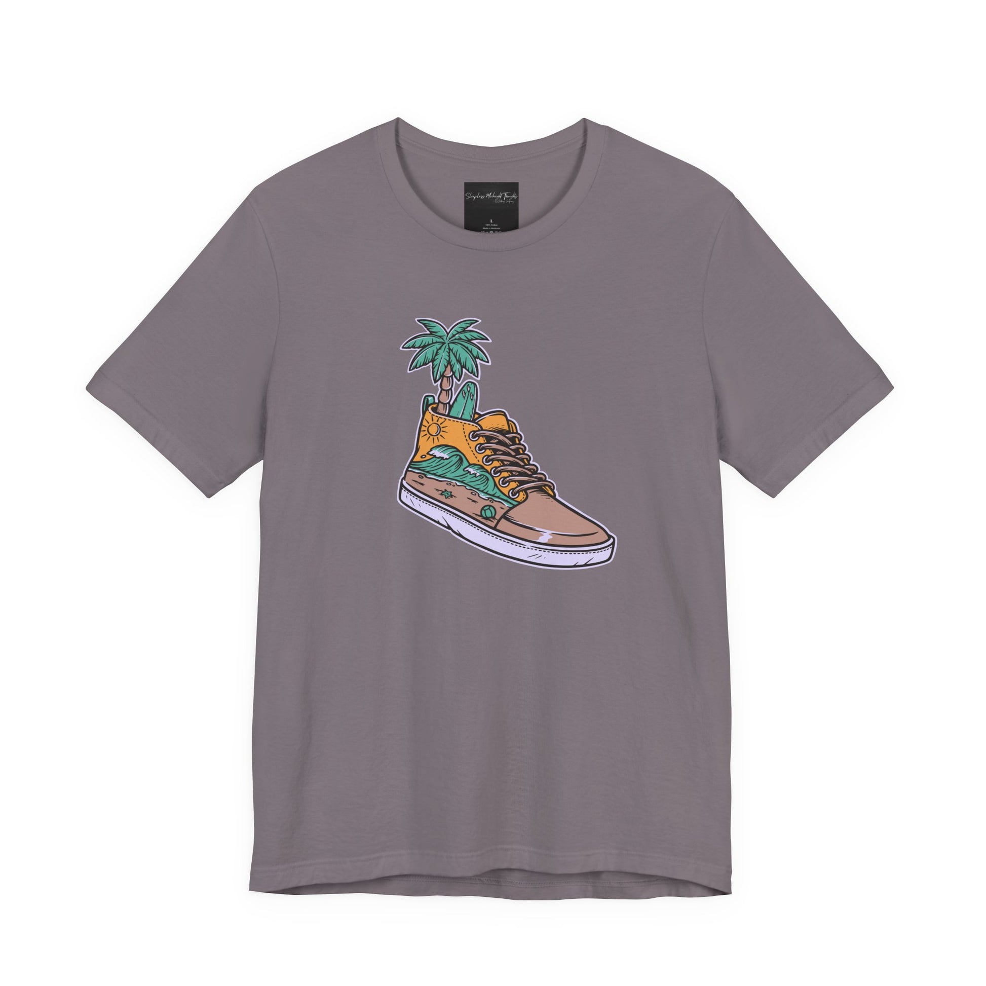 On the front of this custom handmade short sleeve shirt is an image of a high top running shoe with ocean waves running along the side of the shoe, coming out of the top of the shoe where your foot goes is a palm tree and a surf board.