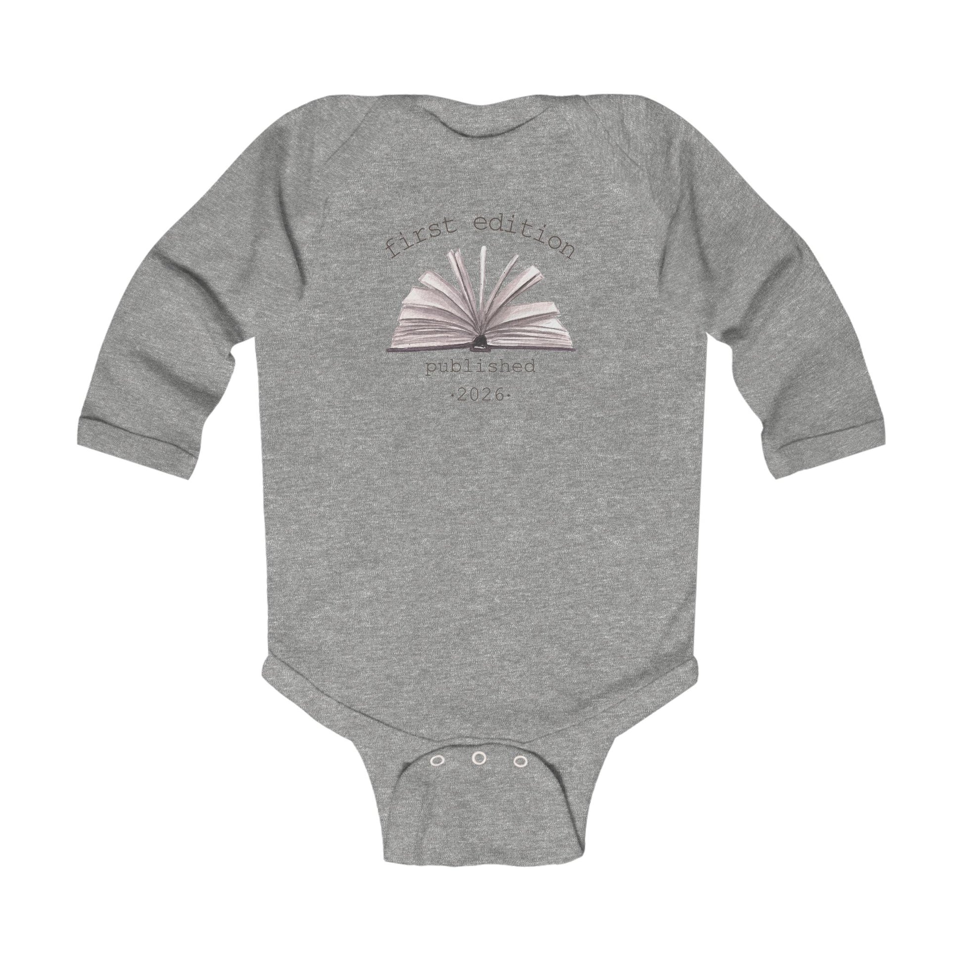 On the front of this custom baby onesie are the words First Edition Published 2026 with an image of an open book in the middle of the wording.