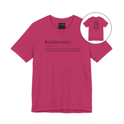 On the front of this custom unisex short sleeve shirt is the word booktrovert with the definition of the word underneath, on the back of the shirt is an image of a large stack of books.