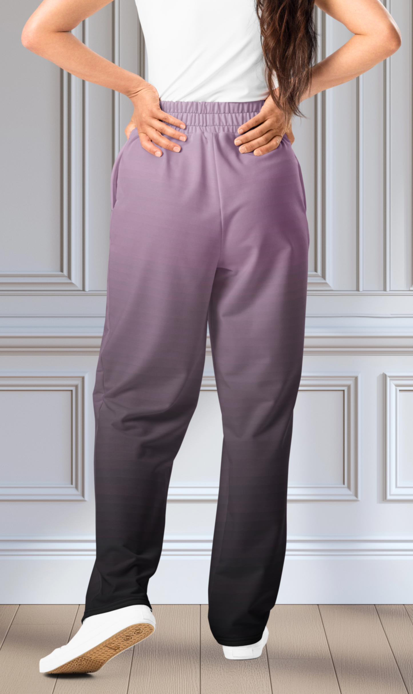 A pair of unisex wide leg joggers that have a ombre pattern starting with a lilac purple at the top then fading to a black at the bottom, the strings are black as well on this pair of pants.