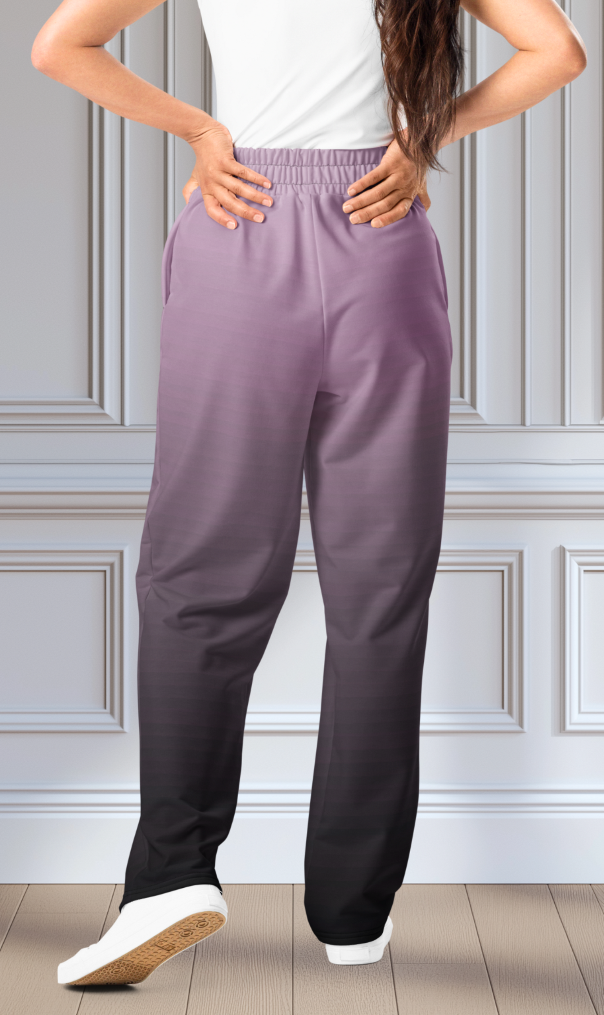 A pair of unisex wide leg joggers that have a ombre pattern starting with a lilac purple at the top then fading to a black at the bottom, the strings are black as well on this pair of pants.