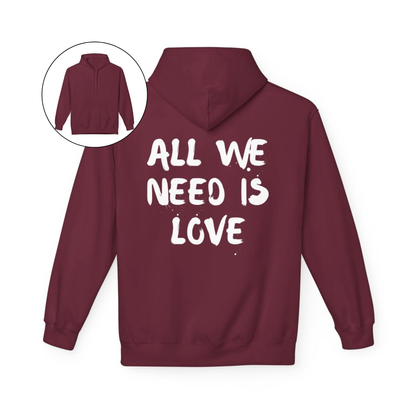 On the back of this custom unisex hoodie are the words all we need is love, the words look like they have been spray painted onto the sweater.