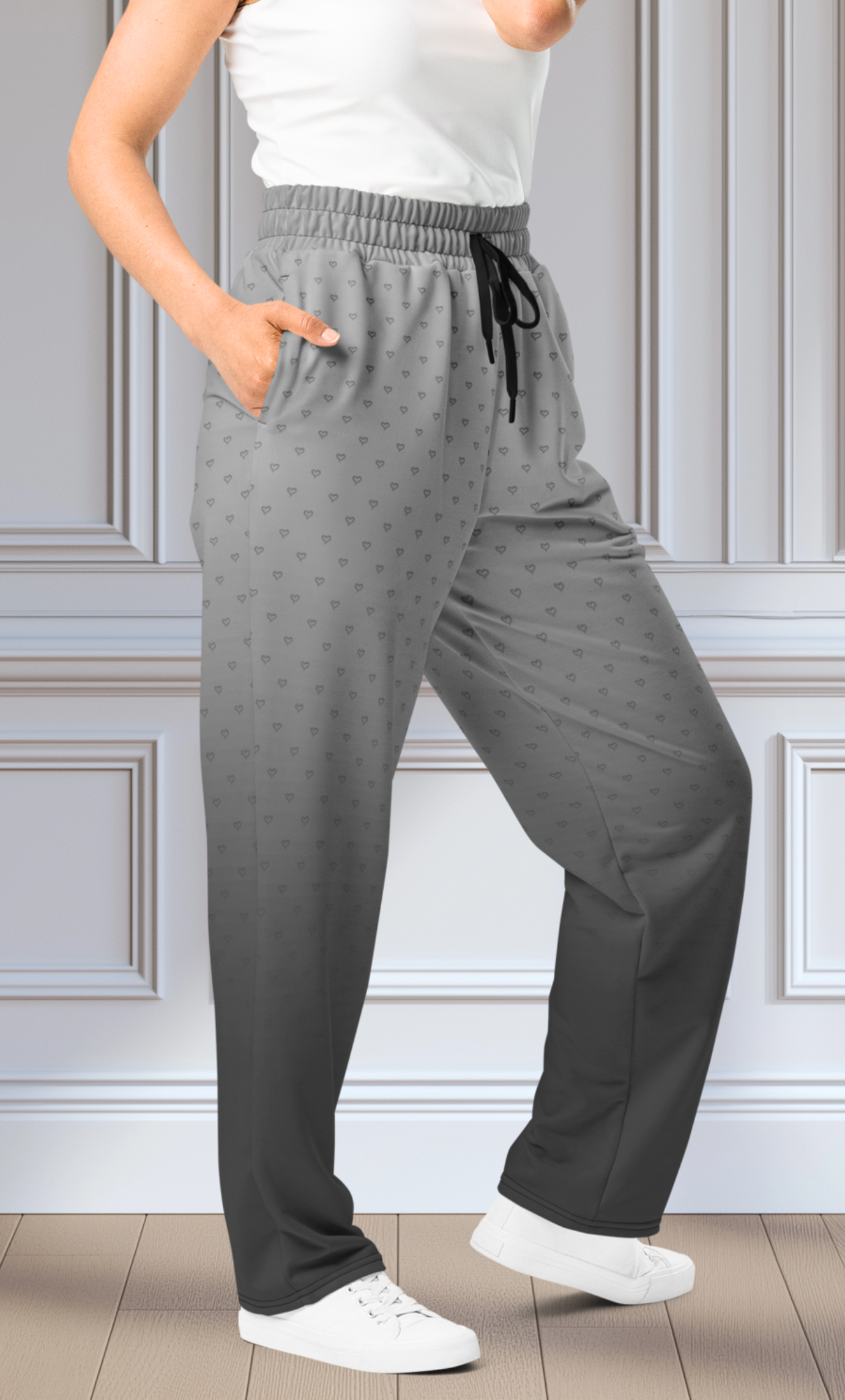 A pair of custom wide leg ombre sweatpants starting off as a light grey at the top then fading to a dark slate at the bottom, there is a dark slate grey heart pattern overlayed on the top that fades into the bottom of the sweatpants.