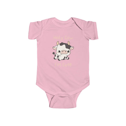 This adorable pink colored super soft bodysuit features an image of a baby cow in the middle with the words 'holy cow I'm cute' in light beige lettering around the image.