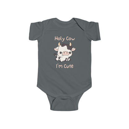 This adorable pink colored super soft bodysuit features an image of a baby cow in the middle with the words 'holy cow I'm cute' in light beige lettering around the image.