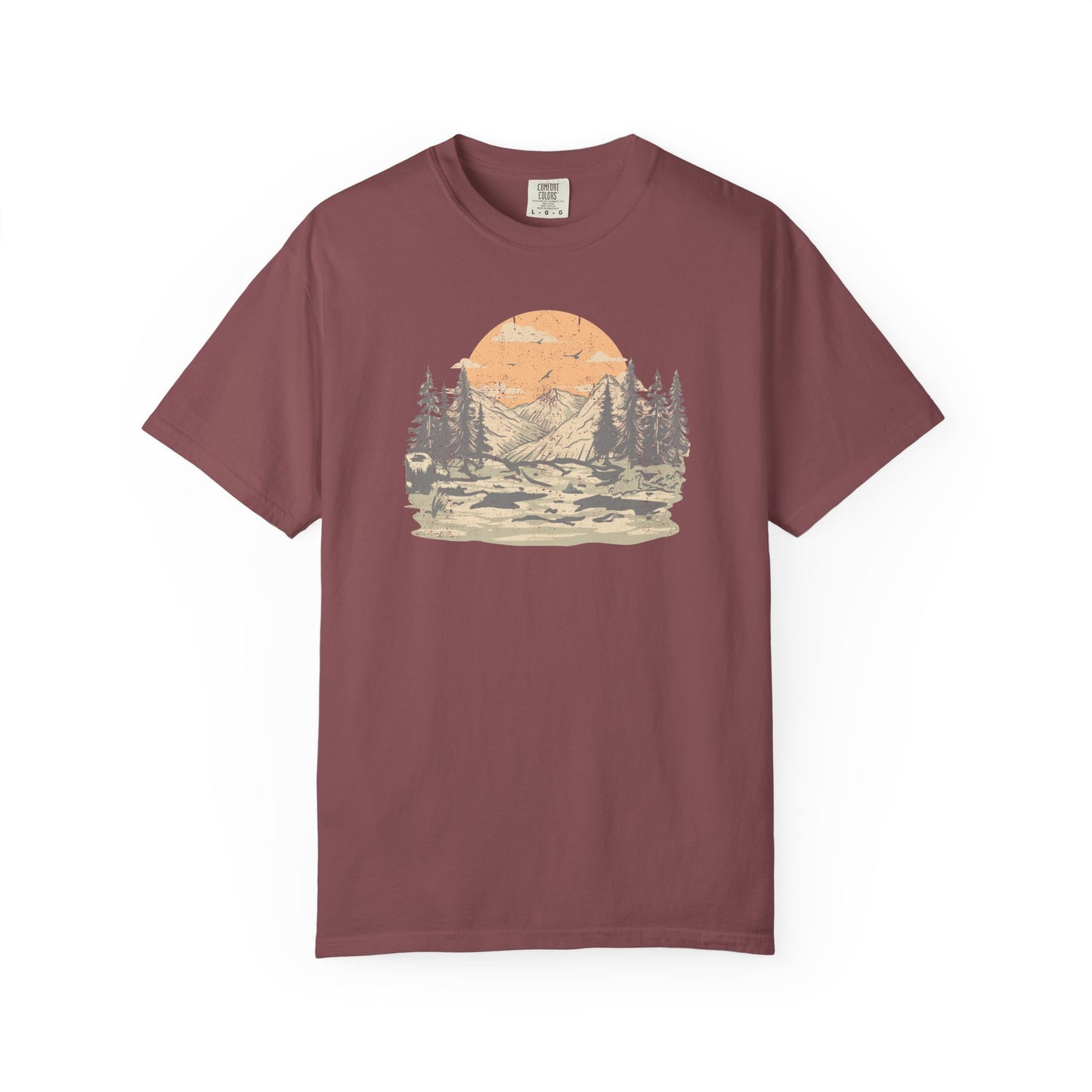 On the front of this custom comfort colors short sleeve t-shirt is a large vintage image of a large valley that opens up to a mountain range with pine trees , there is a large sun in the background with birds flying all around, this t-shirt is completely vintage.