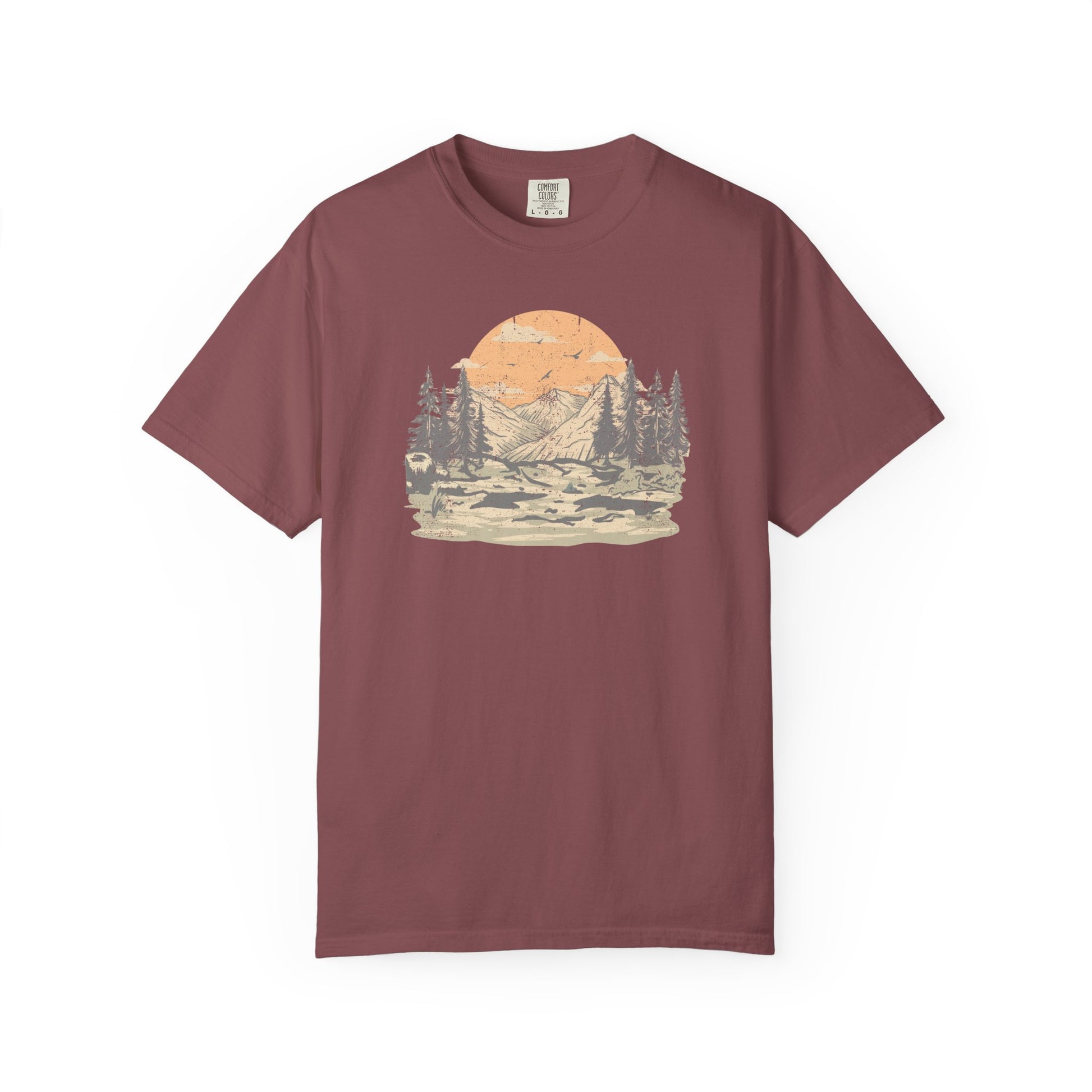 On the front of this custom comfort colors short sleeve t-shirt is a large vintage image of a large valley that opens up to a mountain range with pine trees , there is a large sun in the background with birds flying all around, this t-shirt is completely vintage.