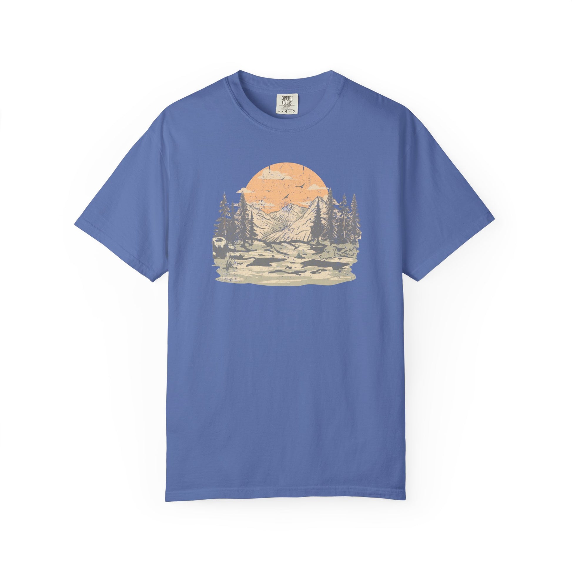On the front of this custom comfort colors short sleeve t-shirt is a large vintage image of a large valley that opens up to a mountain range with pine trees , there is a large sun in the background with birds flying all around, this t-shirt is completely vintage.