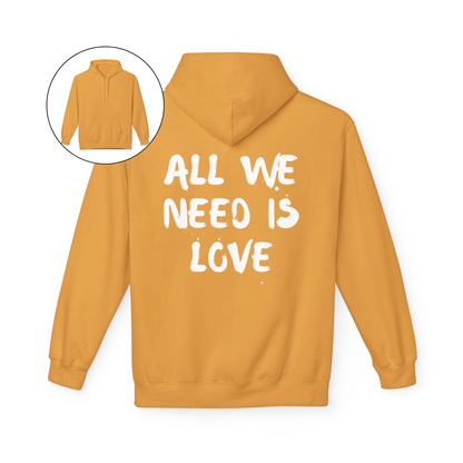 On the back of this custom unisex hoodie are the words all we need is love, the words look like they have been spray painted onto the sweater.
