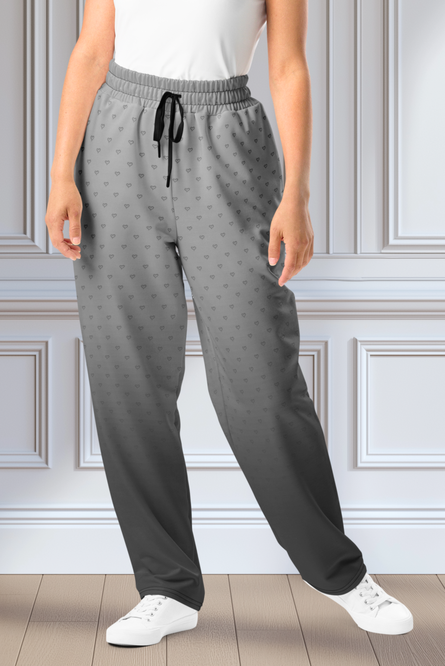 A pair of custom wide leg ombre sweatpants starting off as a light grey at the top then fading to a dark slate at the bottom, there is a dark slate grey heart pattern overlayed on the top that fades into the bottom of the sweatpants.