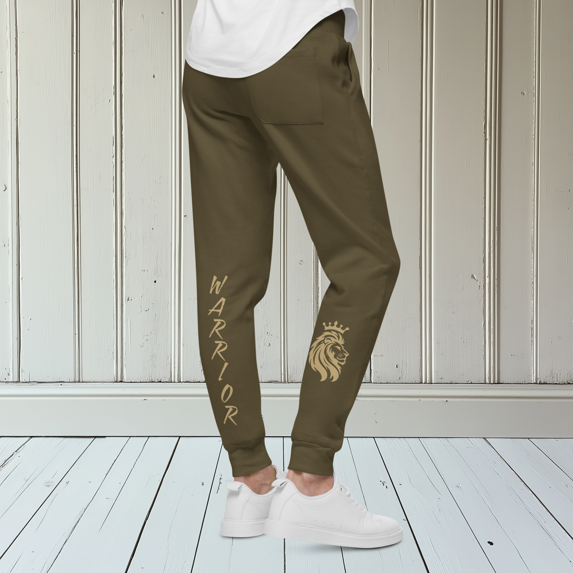 A pair of super soft ankle length unisex sweatpants, there are two pockets on the front and one pocket on the back right, the word warrior is in gold on the back left leg from the knee down and a male lion with a crown on the other