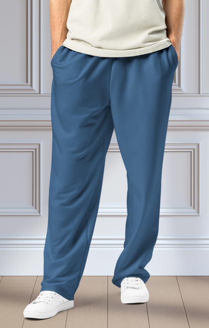 A pair of unisex wide leg joggers that are a ocean blue color from the top to the bottom with the strings of the sweats being black.