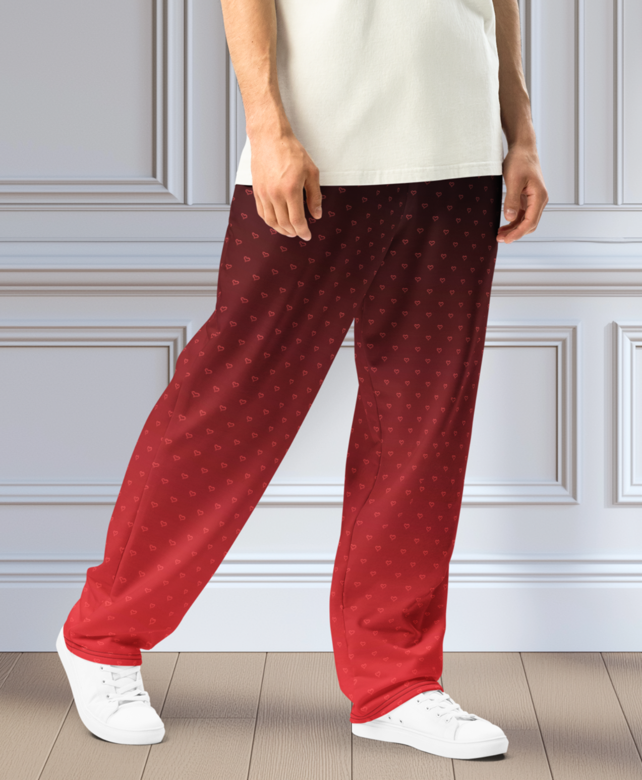 A pair of wide leg ombre sweatpants with the top of the sweats being black and then it fading to a bright red at the bottom of the pants, there are a bunch of red hearts overlayed on the top that then blend into the same shade of red at the bottom of the sweats.