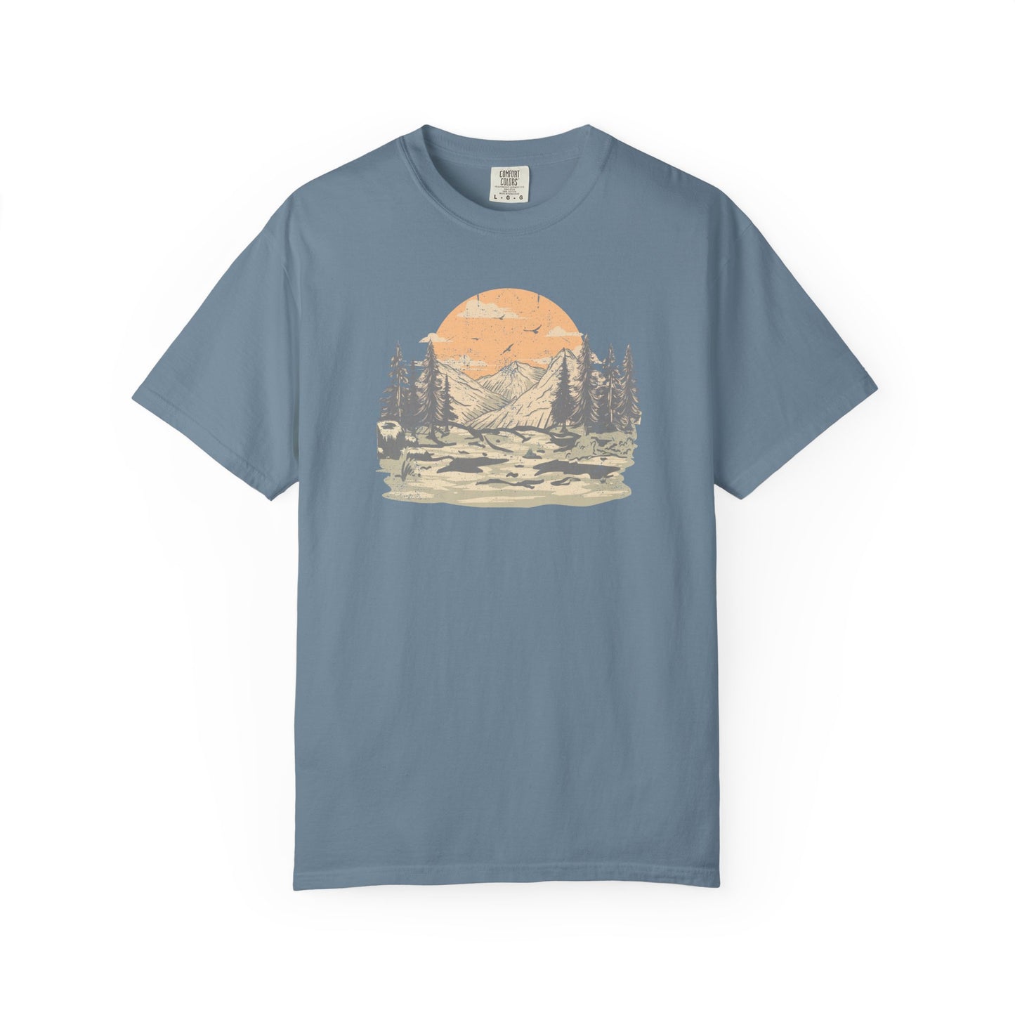 On the front of this custom comfort colors short sleeve t-shirt is a large vintage image of a large valley that opens up to a mountain range with pine trees , there is a large sun in the background with birds flying all around, this t-shirt is completely vintage.