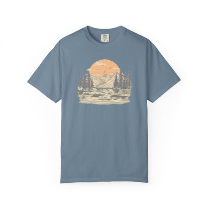 On the front of this custom comfort colors short sleeve t-shirt is a large vintage image of a large valley that opens up to a mountain range with pine trees , there is a large sun in the background with birds flying all around, this t-shirt is completely vintage.