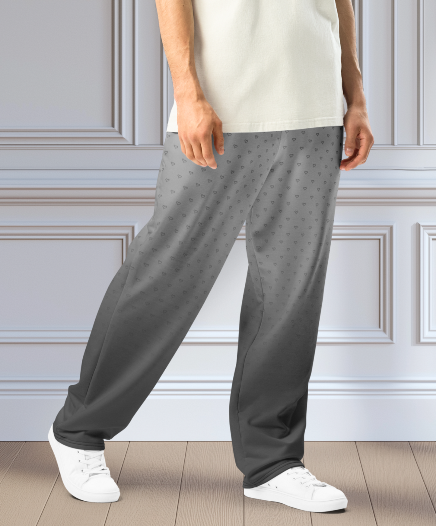 A pair of custom wide leg ombre sweatpants starting off as a light grey at the top then fading to a dark slate at the bottom, there is a dark slate grey heart pattern overlayed on the top that fades into the bottom of the sweatpants.