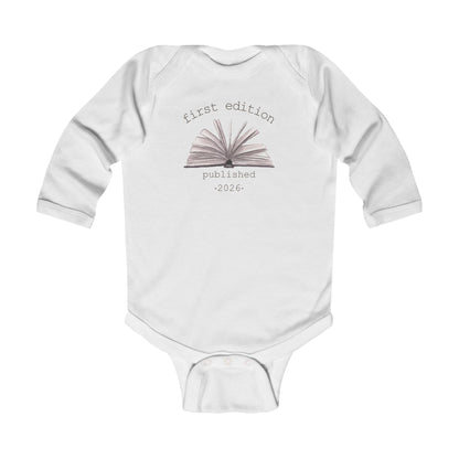 On the front of this custom baby onesie are the words First Edition Published 2026 with an image of an open book in the middle of the wording.