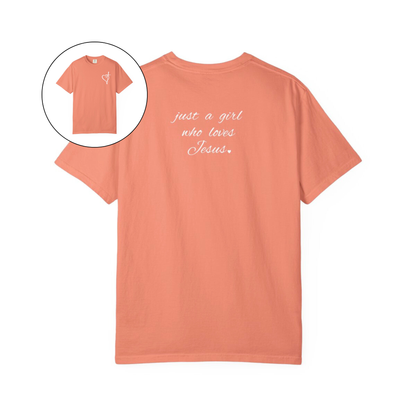 On the front of this custom women's Christian t-shirt is a heart with a cross through it, on the back top of the shirt right between the shoulder blades are the words just a girl who loves Jesus in a cursive writing.