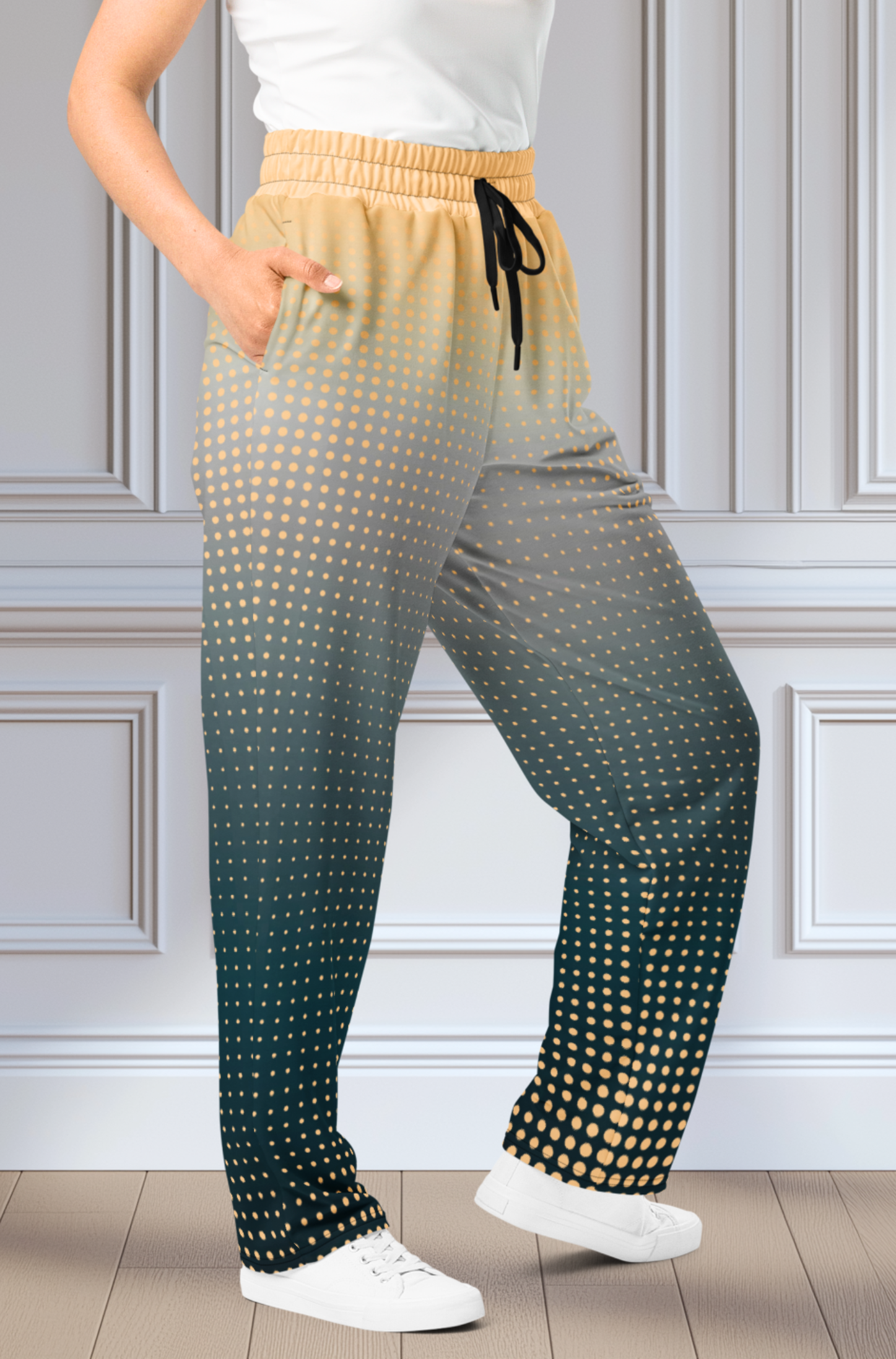A pair of super soft unisex style wide leg jogger with a ombre pattern that starts as a light orange on the top the fades to a deep teal in the middle of the sweats, there is a polka dot pattern that is light orange throughout the top as well.