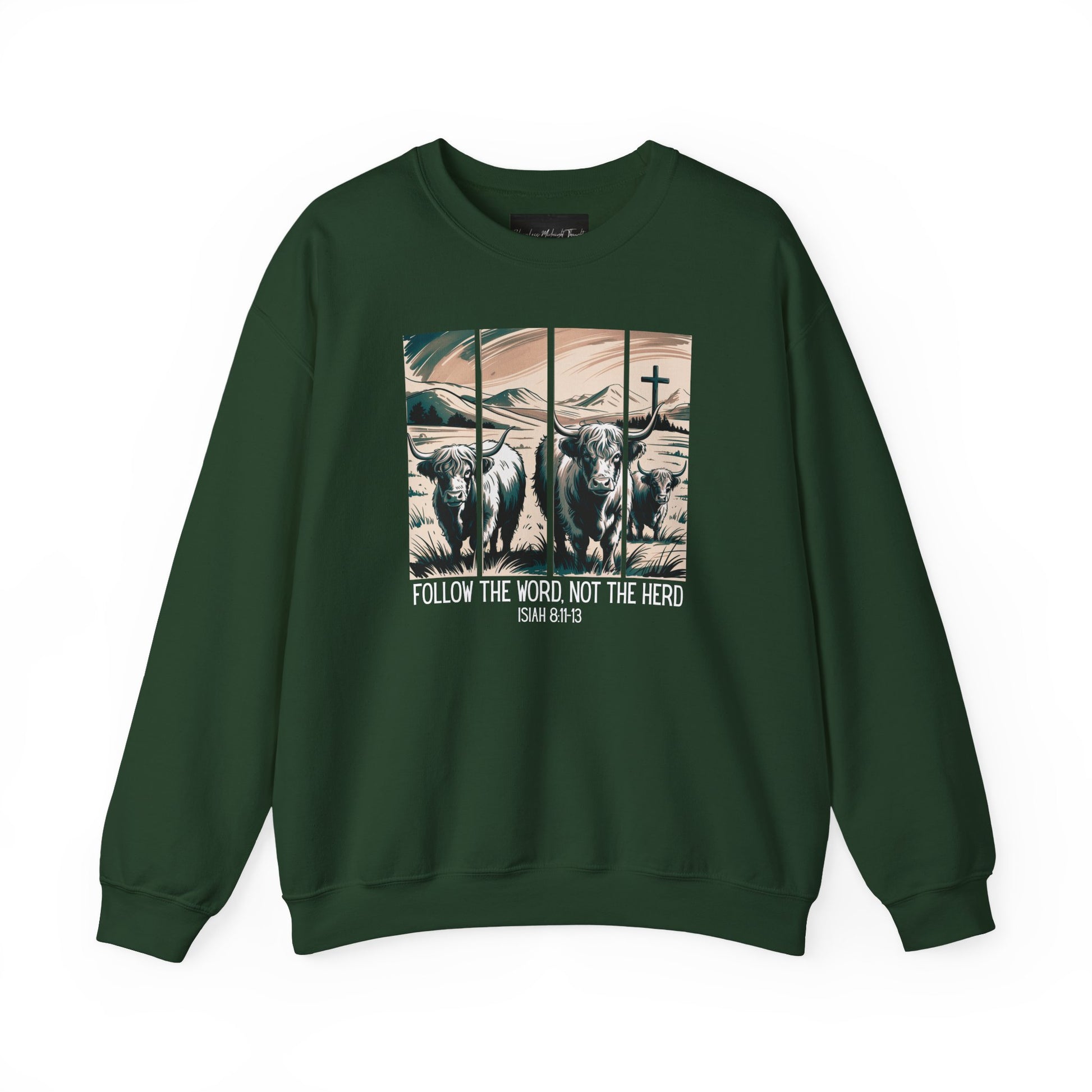 On the front of this Christian pullover sweatshirt is the image of cows standing in a pasture that is in a valley surrounded by mountains, there is a Jesus cross behind the cows, underneath the image is the scripture Follow the word, not the herd Isiah 8:11-13