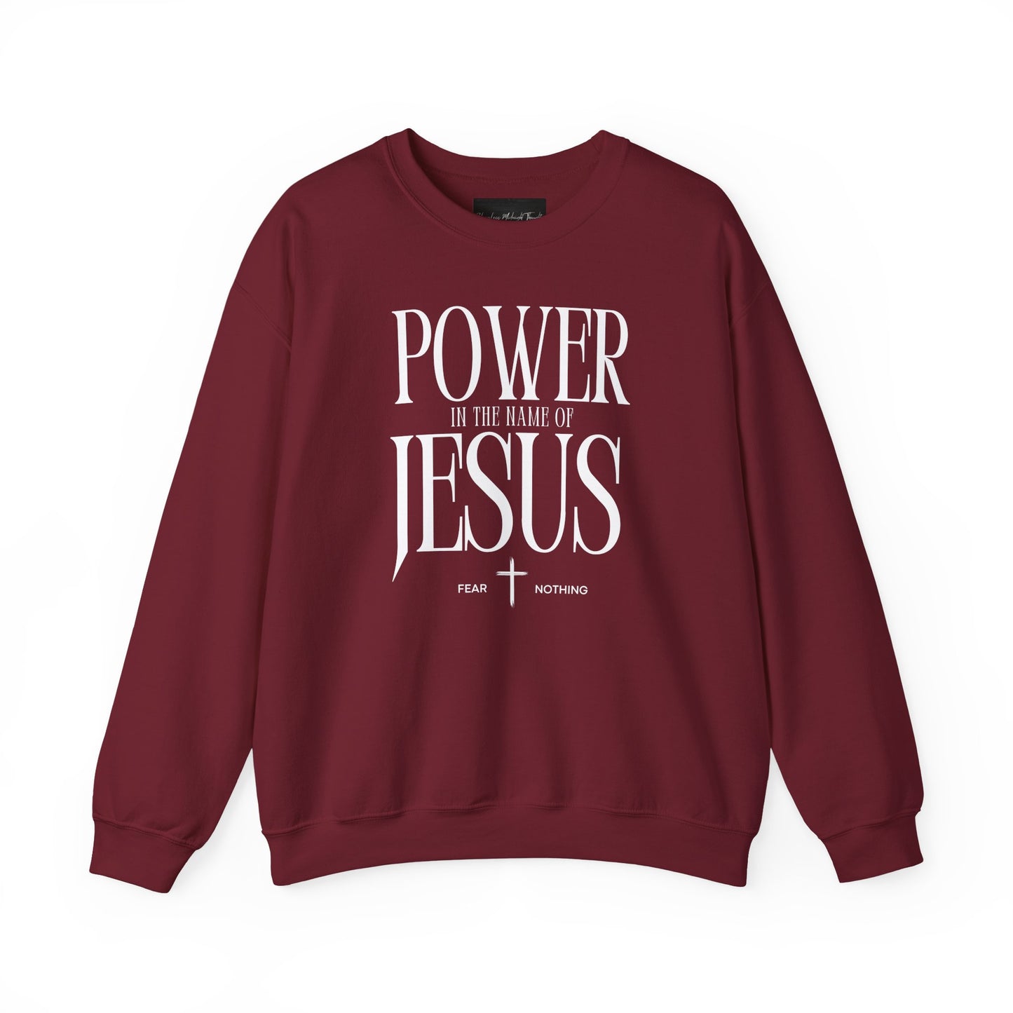 On the front of this Christian pullover sweatshirt it says Power In The Name Of Jesus with a Jesus cross underneath it, on either side of the cross are the words Fear and Nothing.