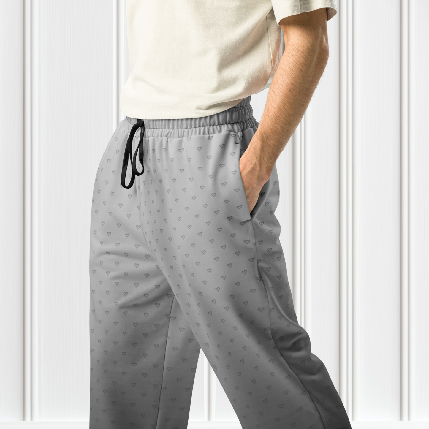 A pair of custom wide leg ombre sweatpants starting off as a light grey at the top then fading to a dark slate at the bottom, there is a dark slate grey heart pattern overlayed on the top that fades into the bottom of the sweatpants.