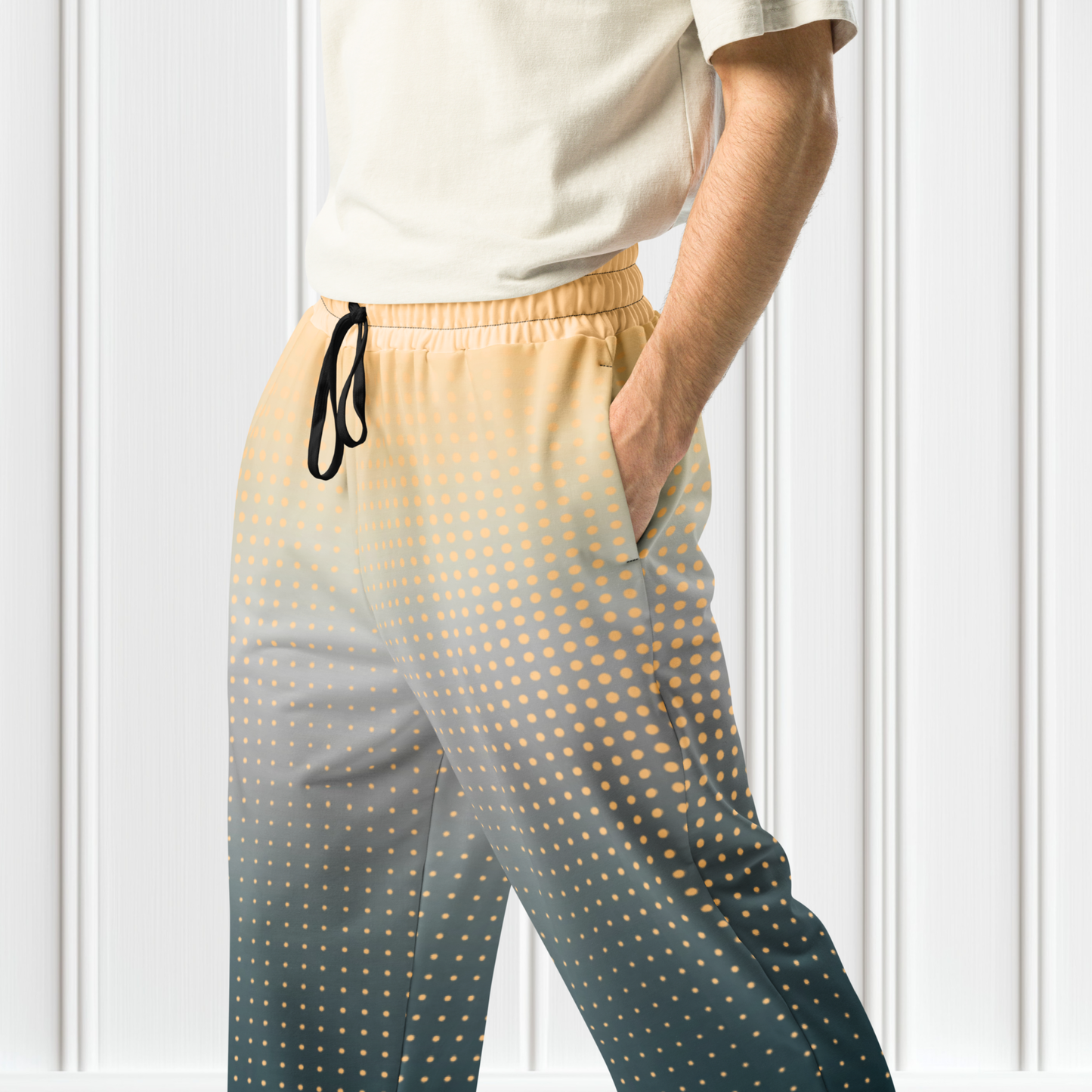 A pair of super soft unisex style wide leg jogger with a ombre pattern that starts as a light orange on the top the fades to a deep teal in the middle of the sweats, there is a polka dot pattern that is light orange throughout the top as well.