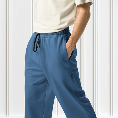 A pair of unisex wide leg joggers that are a ocean blue color from the top to the bottom with the strings of the sweats being black.