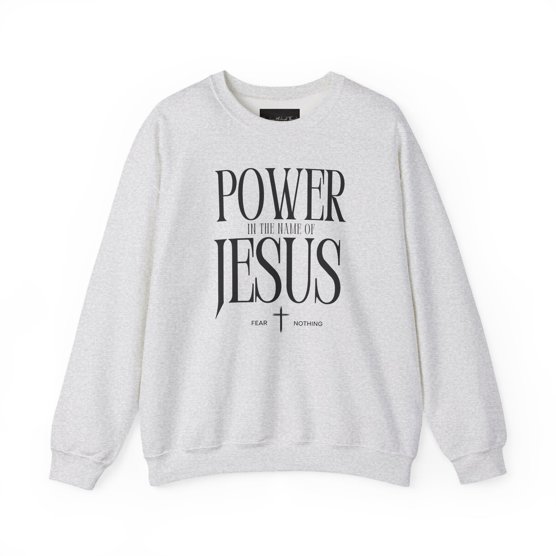 On the front of this Christian pullover sweatshirt it says Power In The Name Of Jesus with a Jesus cross underneath it, on either side of the cross are the words Fear and Nothing.