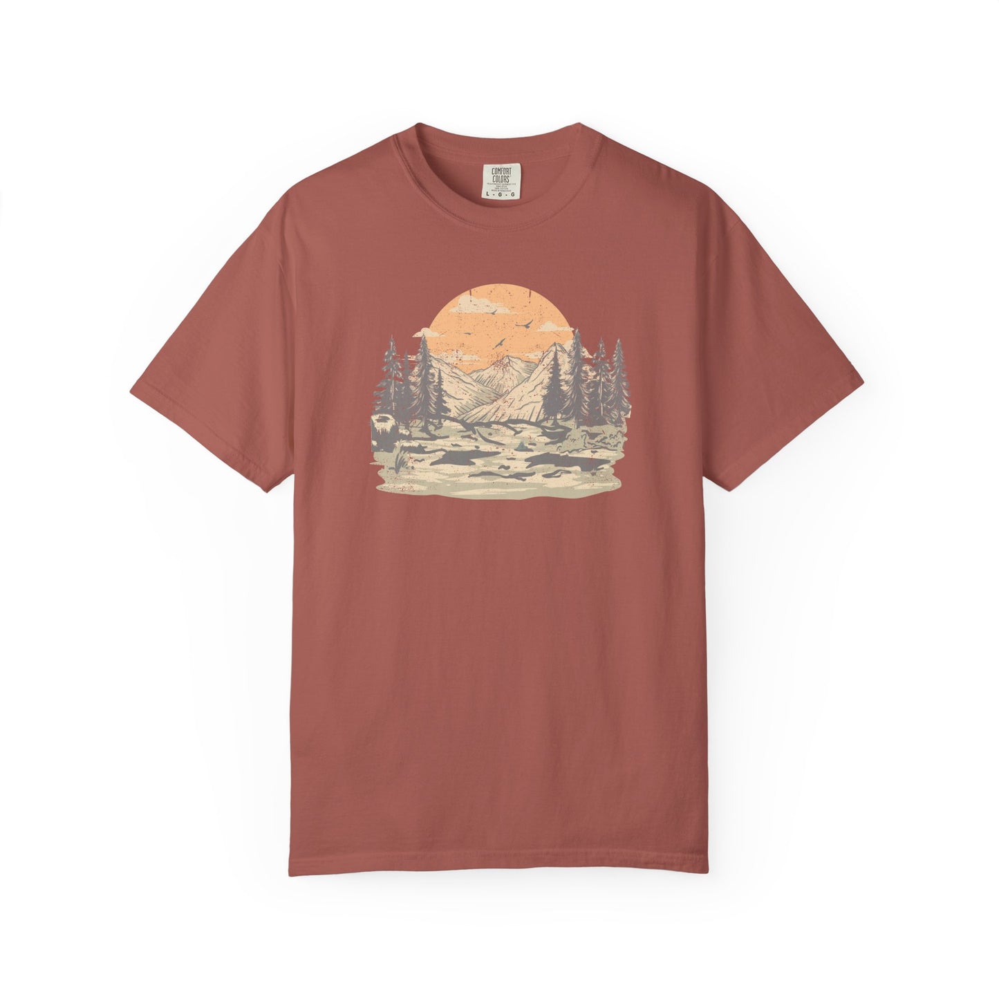 On the front of this custom comfort colors short sleeve t-shirt is a large vintage image of a large valley that opens up to a mountain range with pine trees , there is a large sun in the background with birds flying all around, this t-shirt is completely vintage.