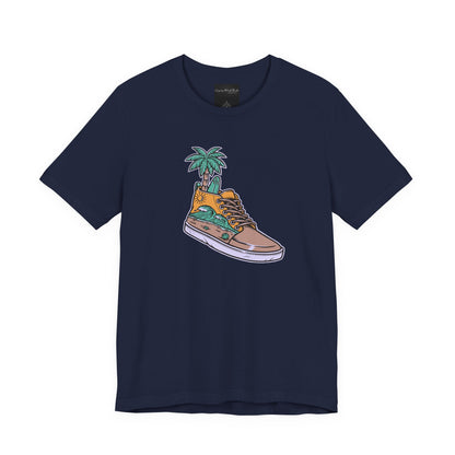 On the front of this custom handmade short sleeve shirt is an image of a high top running shoe with ocean waves running along the side of the shoe, coming out of the top of the shoe where your foot goes is a palm tree and a surf board.
