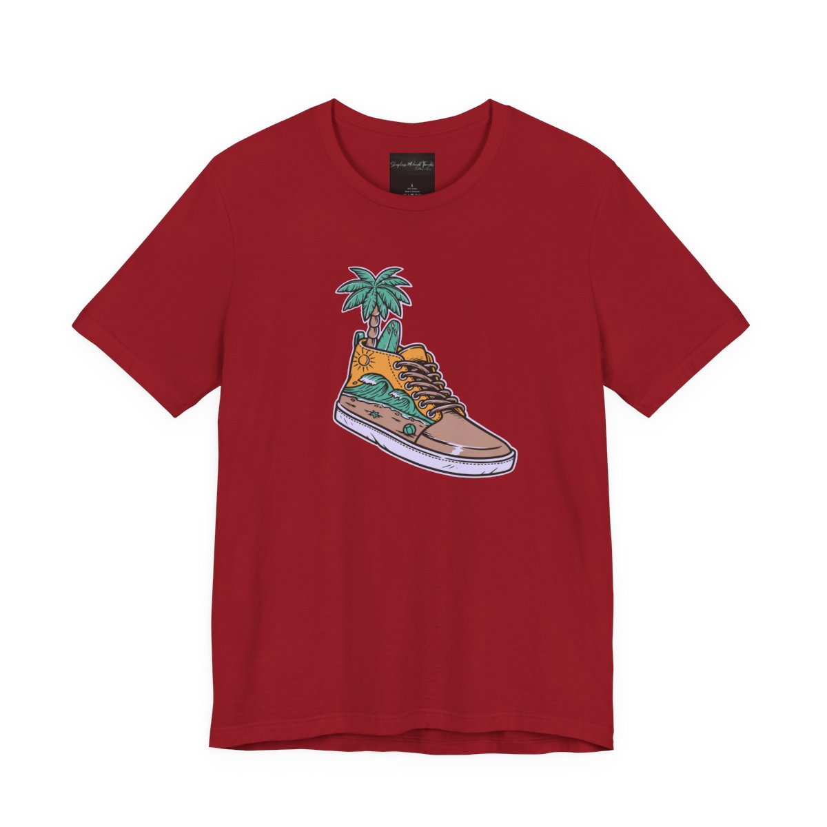 On the front of this custom handmade short sleeve shirt is an image of a high top running shoe with ocean waves running along the side of the shoe, coming out of the top of the shoe where your foot goes is a palm tree and a surf board.