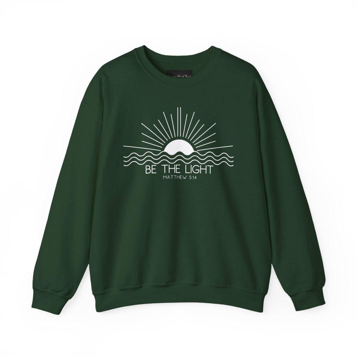 This cozy Christian crewneck sweatshirt features a sunrise over the ocean in the background with the bible verse Be the Light Matthew 5:14 in front of the image.