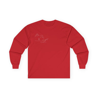 This Christian unisex Long Sleeve t-shirt features the words Be The Light Matthew 5:14 in a simple cursive font with an image of a line drawing of a candle next to the word light.