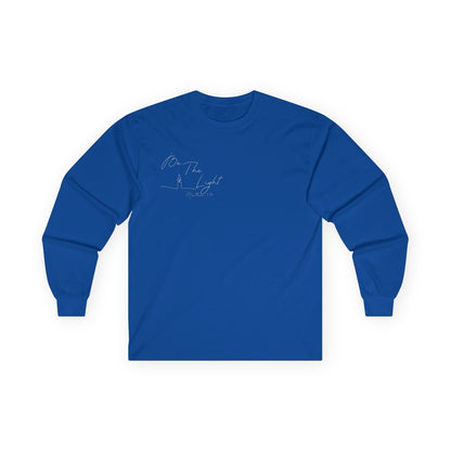 This Christian unisex Long Sleeve t-shirt features the words Be The Light Matthew 5:14 in a simple cursive font with an image of a line drawing of a candle next to the word light.