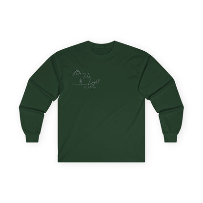 This Christian unisex Long Sleeve t-shirt features the words Be The Light Matthew 5:14 in a simple cursive font with an image of a line drawing of a candle next to the word light.