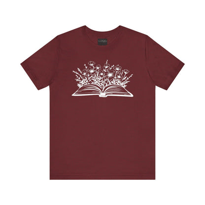 On the front of this custom women's book lover shirt is a image of a book with it opened in the middle, there are a bunch of wildflowers coming out of the center of the book.