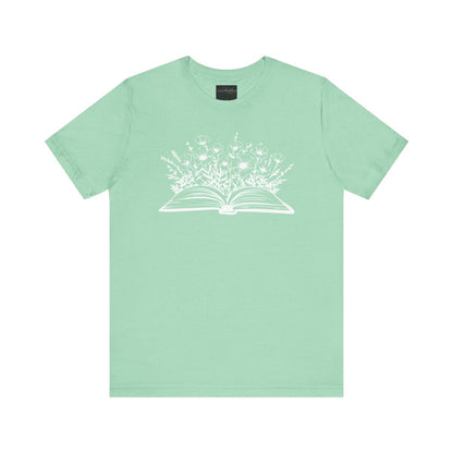 On the front of this custom women's book lover shirt is a image of a book with it opened in the middle, there are a bunch of wildflowers coming out of the center of the book.