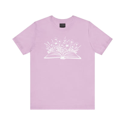 On the front of this custom women's book lover shirt is a image of a book with it opened in the middle, there are a bunch of wildflowers coming out of the center of the book.