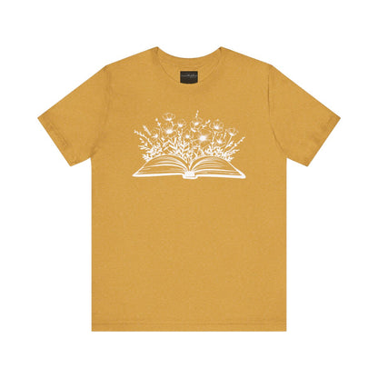 On the front of this custom women's book lover shirt is a image of a book with it opened in the middle, there are a bunch of wildflowers coming out of the center of the book.