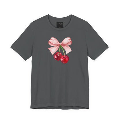 On the front of this custom women's short sleeve shirt is an image of a pair of cherries hanging from a stem with a pink bow on the top of them.
