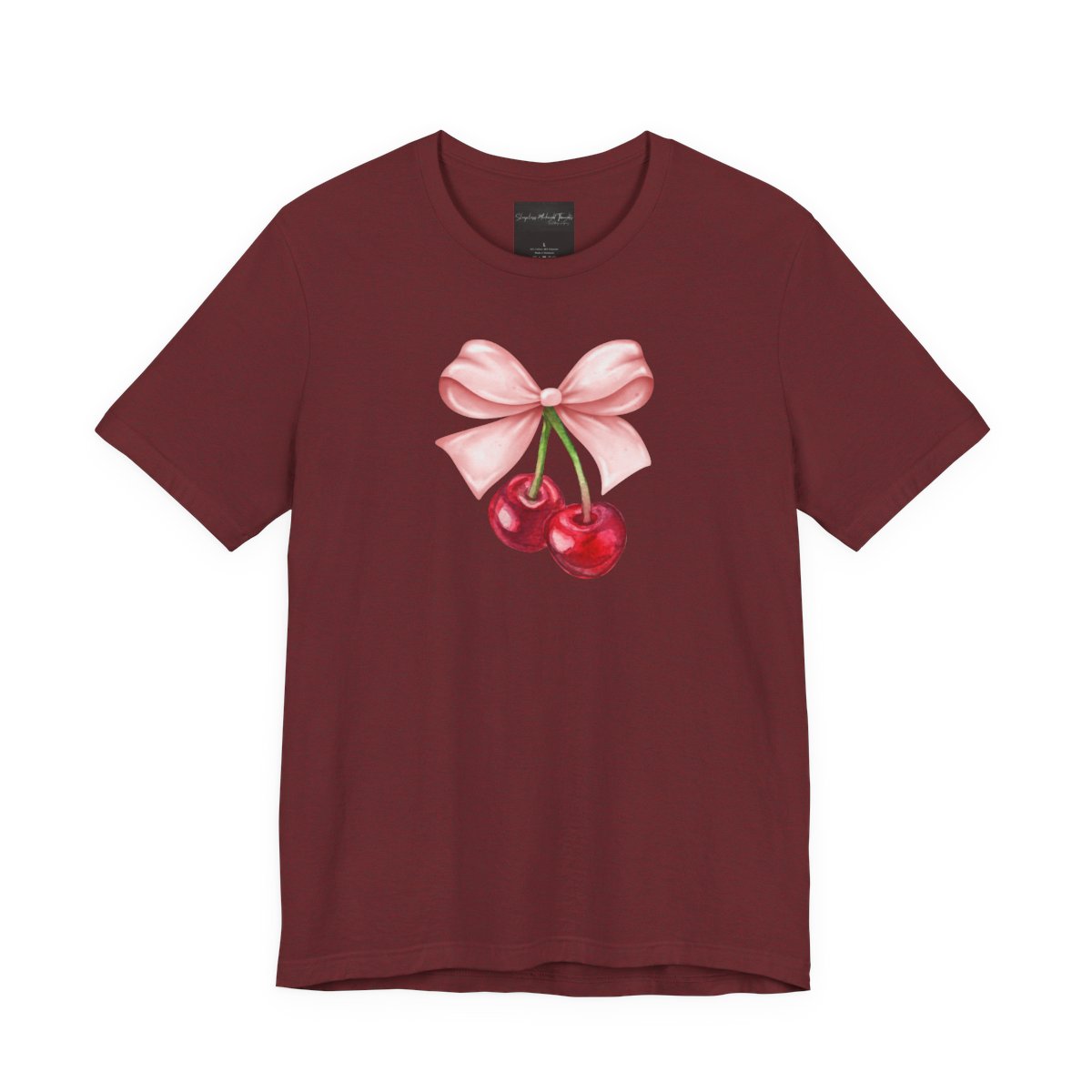 On the front of this custom women's short sleeve shirt is an image of a pair of cherries hanging from a stem with a pink bow on the top of them.