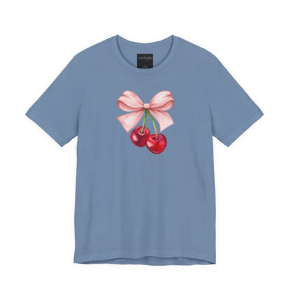 On the front of this custom women's short sleeve shirt is an image of a pair of cherries hanging from a stem with a pink bow on the top of them.